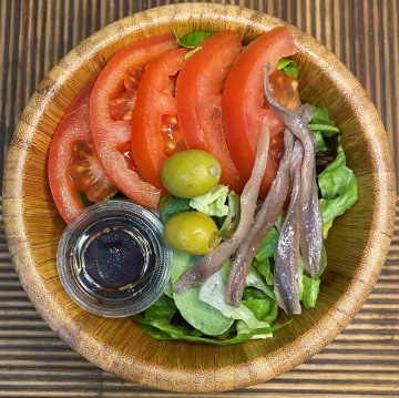 Ensalada de brotes con tomate, anchoas  aceitunas | Platos fuera de temporada